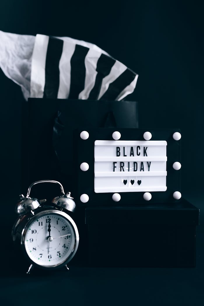Black Friday shopping setup with an alarm clock and promotional sign.